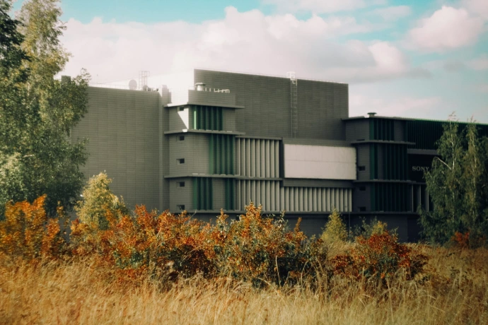 Modern building facade with green accents and trees